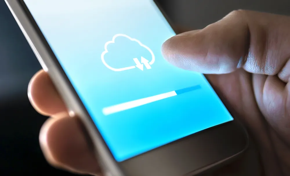 shutterstock_1399145957 Cloud-Ladesymbol auf dem Bildschirm eines Smartphone